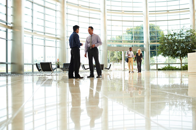 2 men conferring in building lobby